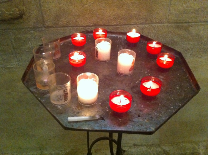 Candles in the church opposite the castle Walking The way of St James between St Come D'Olt and Estaing written and prohotographed by Charles Hawes. Route St Jacques.